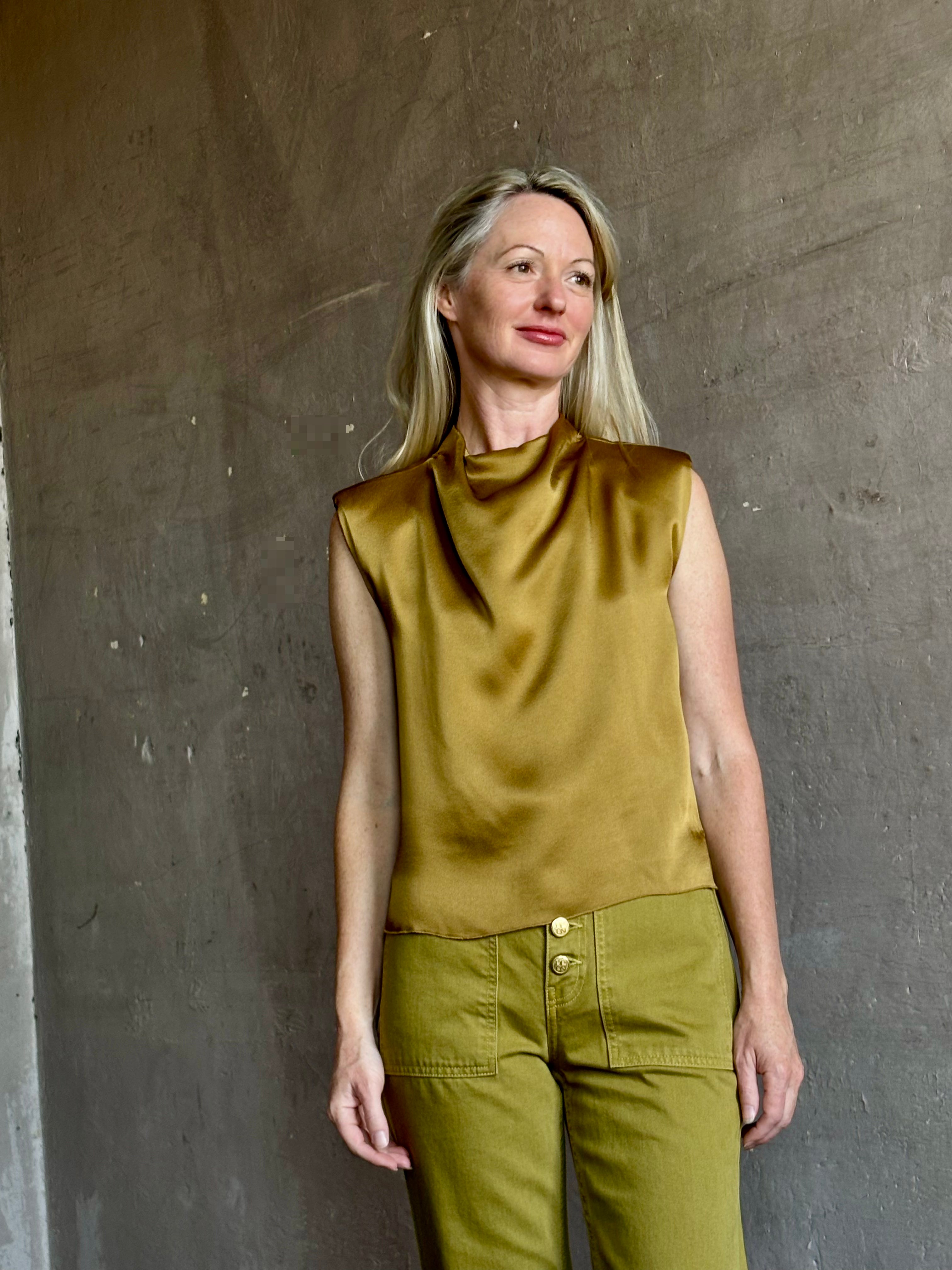 Image of mature woman wearing luxury Italian designer FORTE FORTE Envers Satin Crater-Neck sleeveless Shirt in matte Antique Gold 