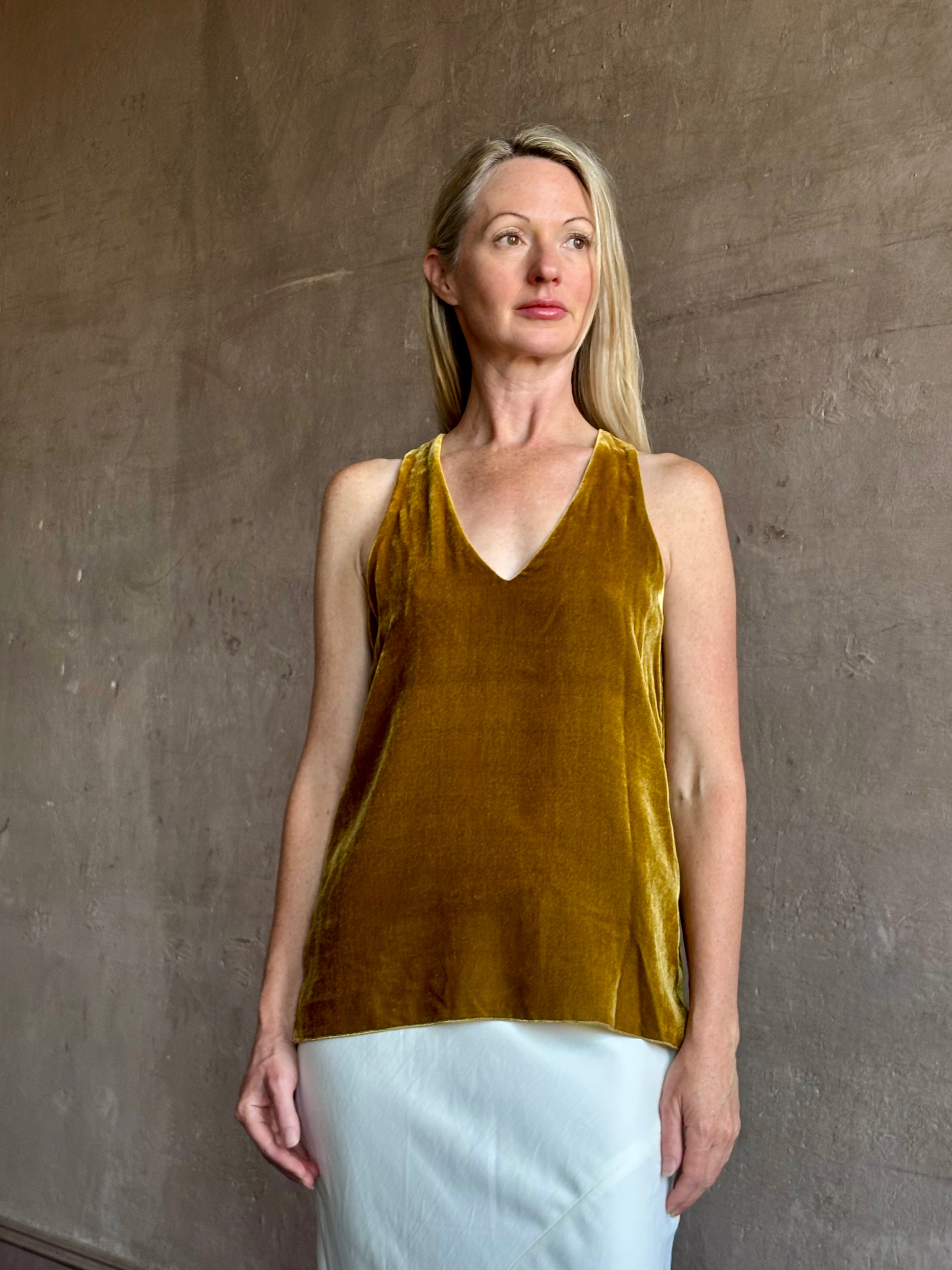 Image of mature woman wearing luxury Italian designer FORTE FORTE Plain sleeveless Velvet V Neck Top in Antique Gold with exquisite draping
