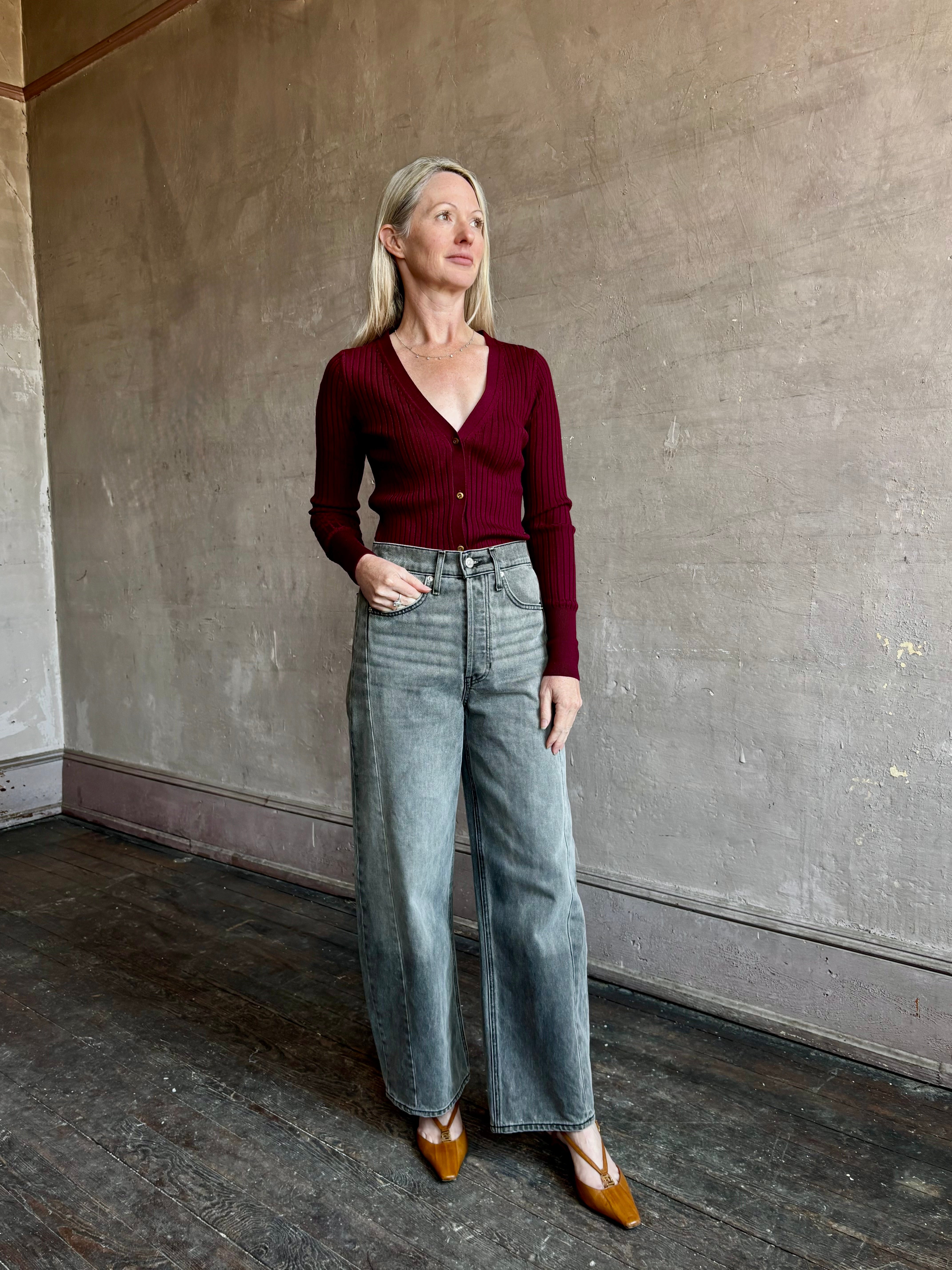 Image of woman wearing premium virgin wool cardigan with v-neck, ribbed texture and long sleeves in a rich burgundy 