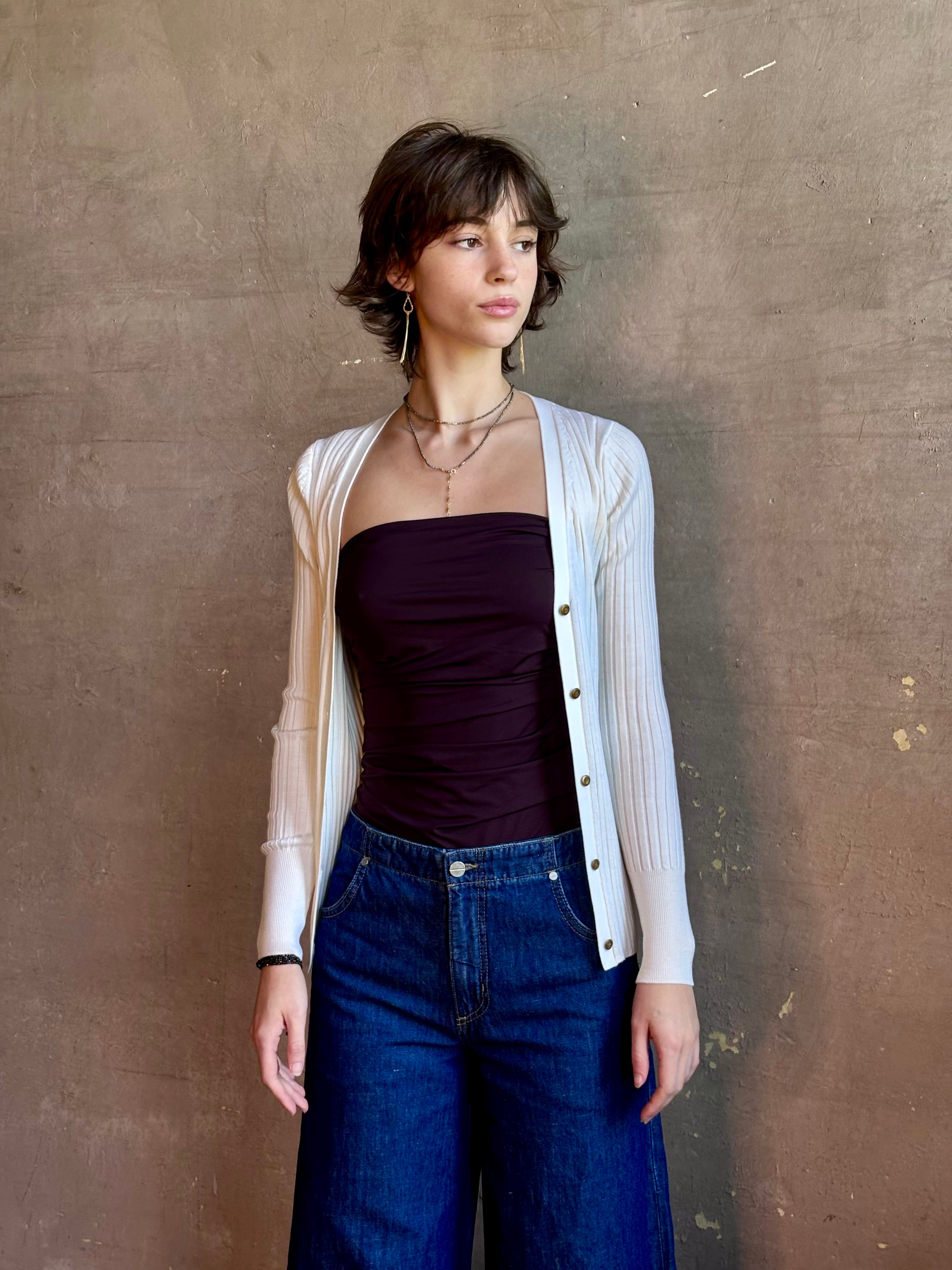 Woman wearing timeless luxury Italian knitwear by FORTE FORTE Superfine Merino Ribbed Cardigan in Neve off-white with v-neck, button front and long sleeves