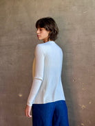 Woman wearing luxury Italian knitwear by FORTE FORTE Superfine Merino Ribbed Cardigan in Neve off-white with v-neck, button front and long sleeves