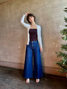Woman wearing luxury Italian knitwear by FORTE FORTE Superfine Merino Ribbed Cardigan in Neve off-white with v-neck, button front and long sleeves