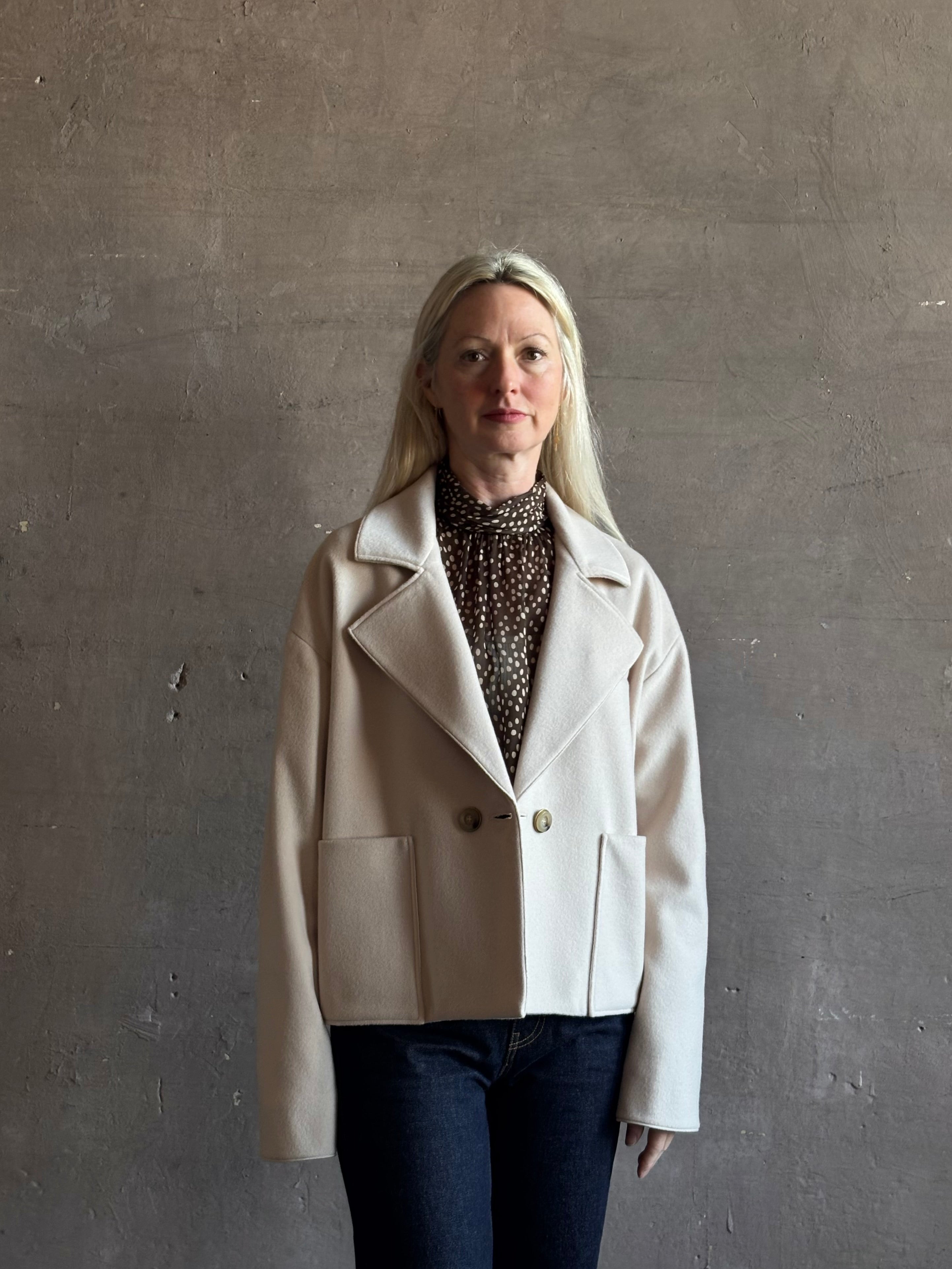 Mature woman wearing expertly tailored Forte Forte beige jacket in premium virgin wool and cashmere 