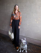 Image featuring a woman wearing the Coreana voile shirt by Forte Forte in a lightweight cotton silk rust color body and print with teal fauna and pink shells.