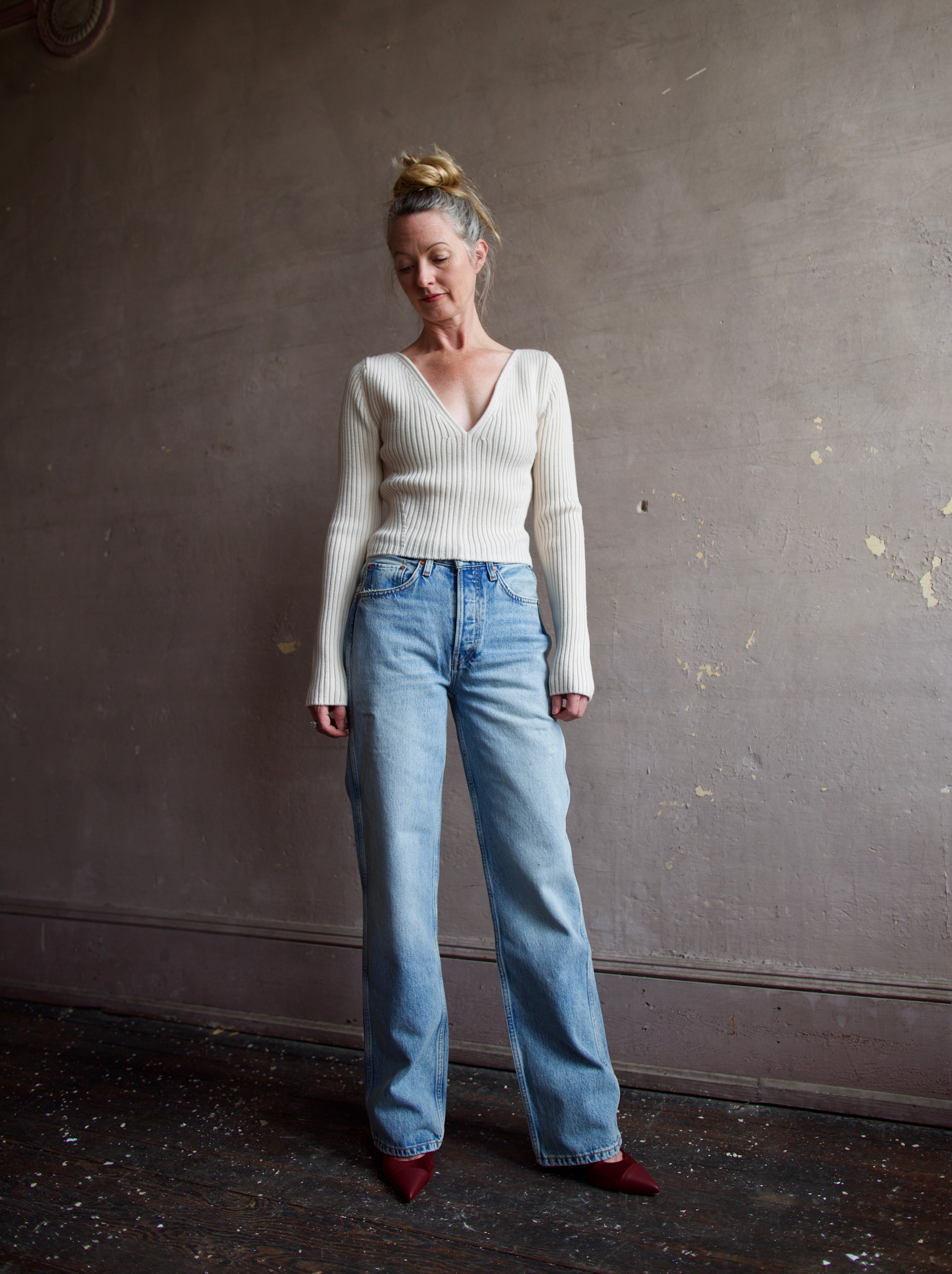 Image featuring a woman wearing the Forte Forte Deep Neckline Ribbed Stretch Merino Sweater with a v-neckline and a cropped fit.