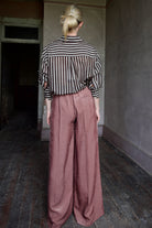 Mature woman wearing Italian designer Forte_Forte Fluid Chic Corduroy Pants in rose sweeping wide-leg silhouette pleated front