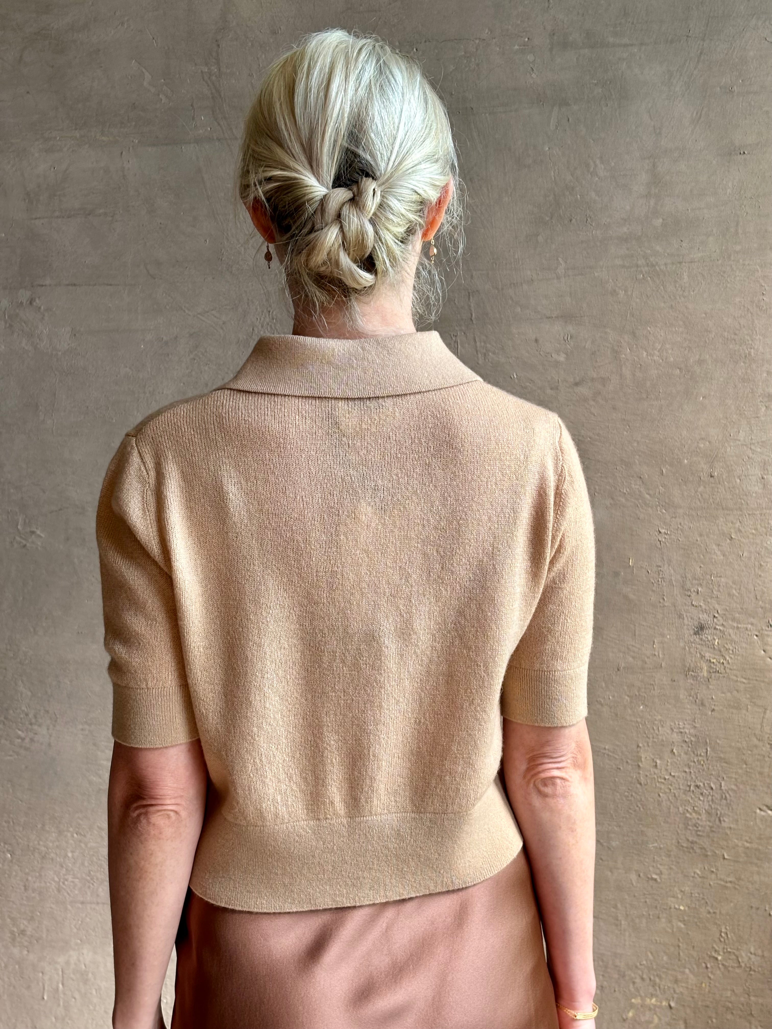 Mature woman wearing an elevated basic short sleeve polo sweater by luxury Italian designer Forte Forte rendered in a comfortable light weight wool and cashmere blend