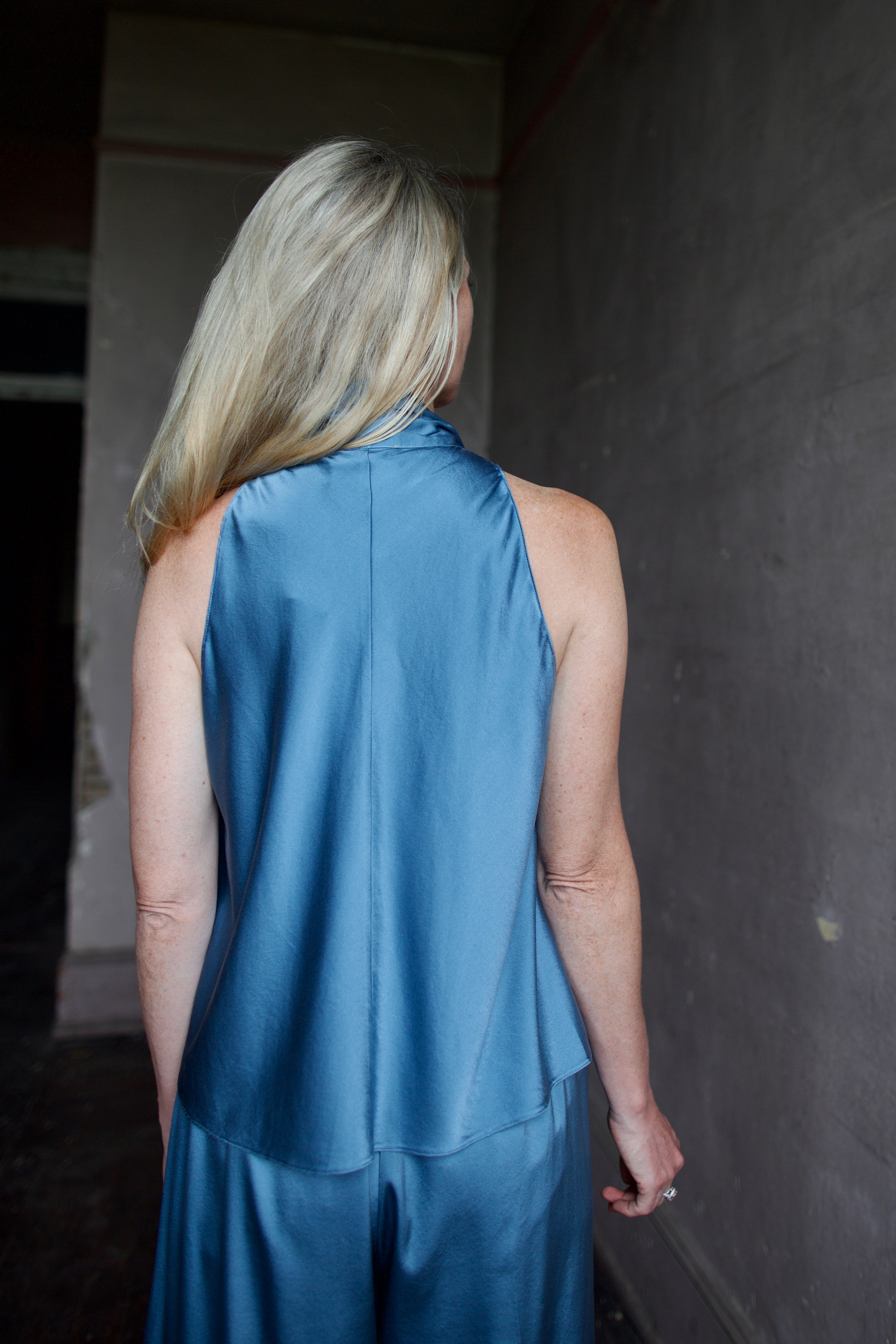 Back of model wearing high-end designer Forte Forte blue silk sleeveless top and pant set 