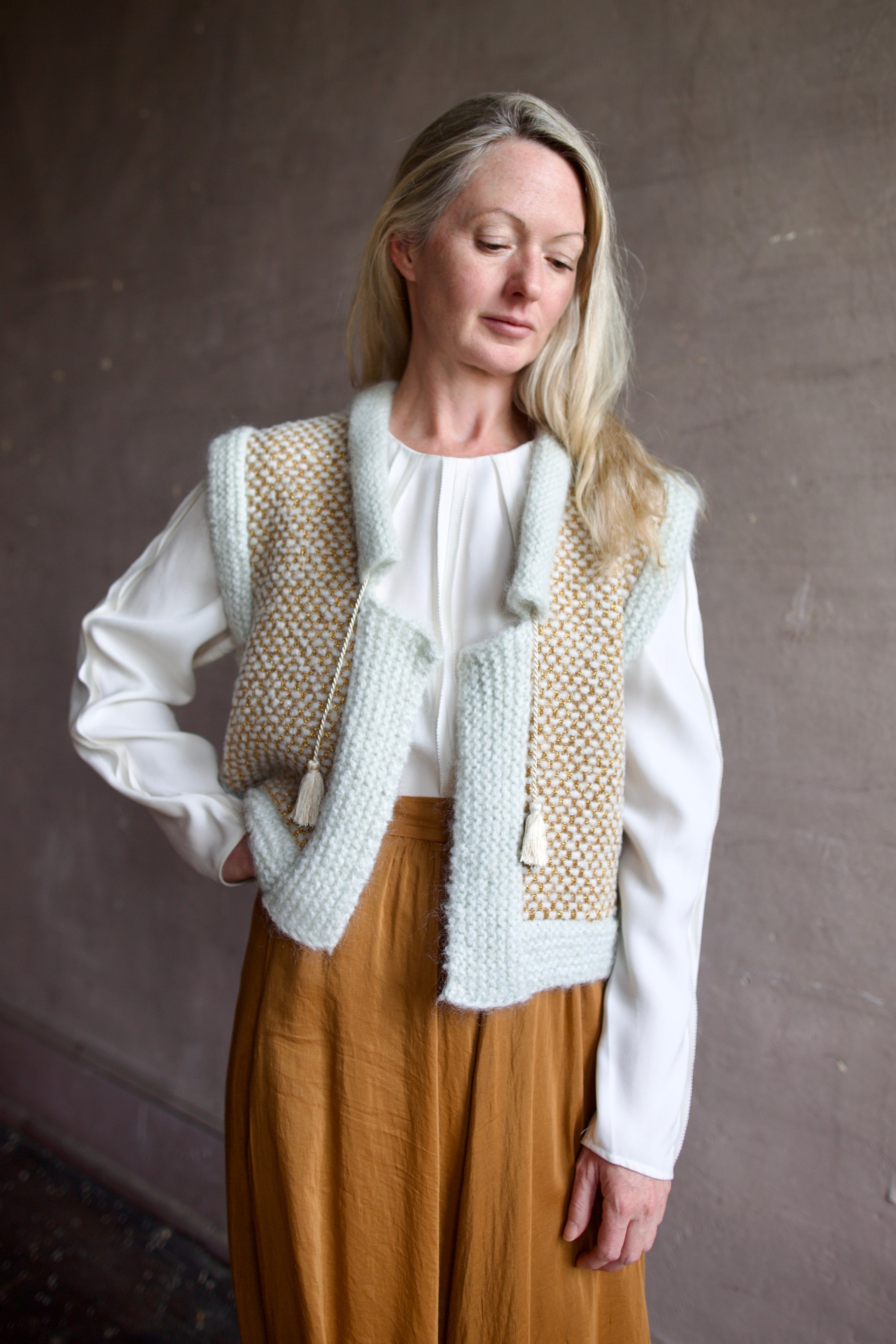 Senior model wearing designer clothing Ulla Johnson white blouse with Forte Forte  skirt and mint green layering sweater vest 