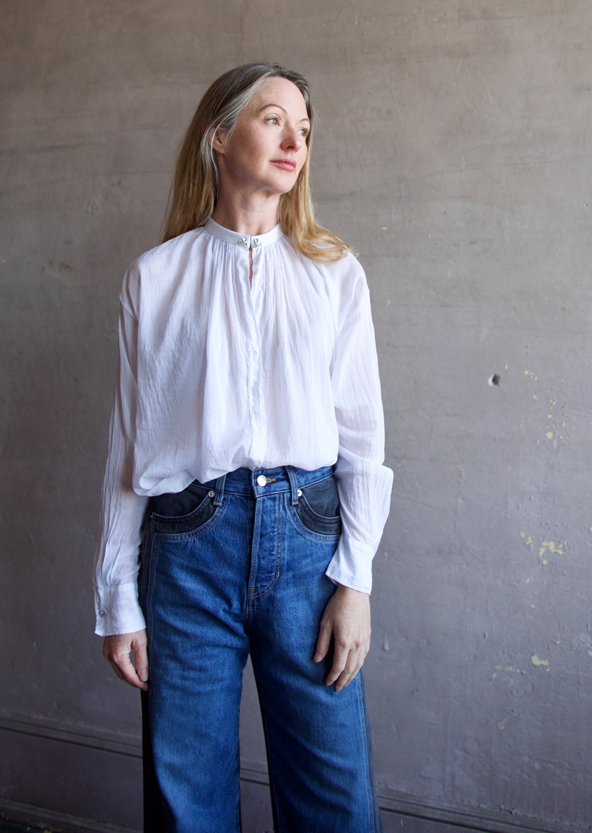 Image featuring a woman wearing the voile bohemian shirt by Forte Forte with a hook and eye closure and crystal embellishment at  the mandarin collar and sleeve button.