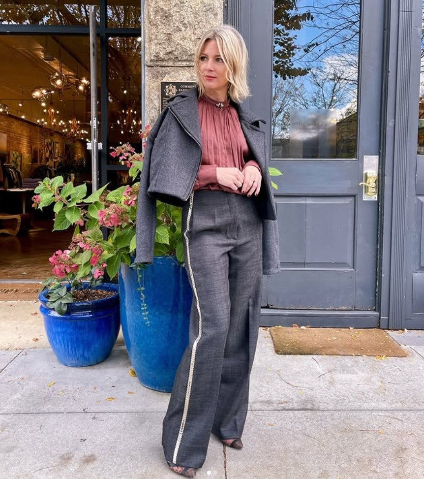Mature woman wearing Forte_Forte's tailored Grey Herringbone Pants in virgin wool asymmetrical sequence embellishment down side