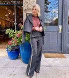 Mature woman wearing Forte_Forte's tailored Grey Herringbone Pants in virgin wool asymmetrical sequence embellishment down side