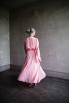 Image of a woman wearing the voile long sleeve dress by Forte Forte with a deep v neckline and tailored waist fabricated in pink cotton silk.