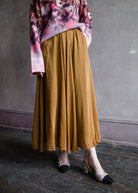 Image featuring a woman wearing the essential voile skirt by Forte Forte in caramel with a high rise and elastic at the back and a flowy fit in cotton silk fabric.