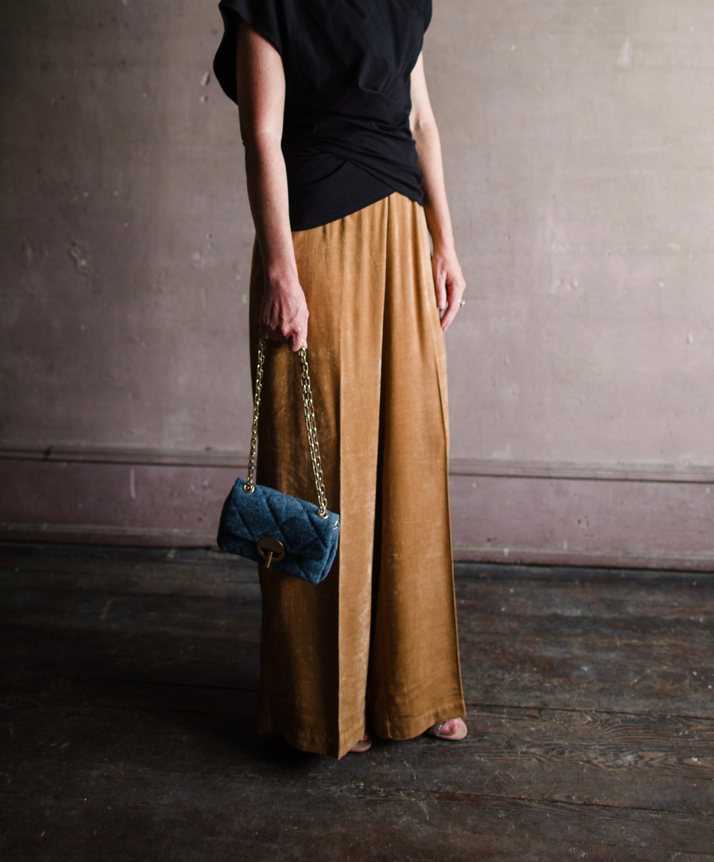 Image featuring a woman wearing the matte corduroy pants by Forte Forte with an elastic waist and flowy wide leg in caramel brown.