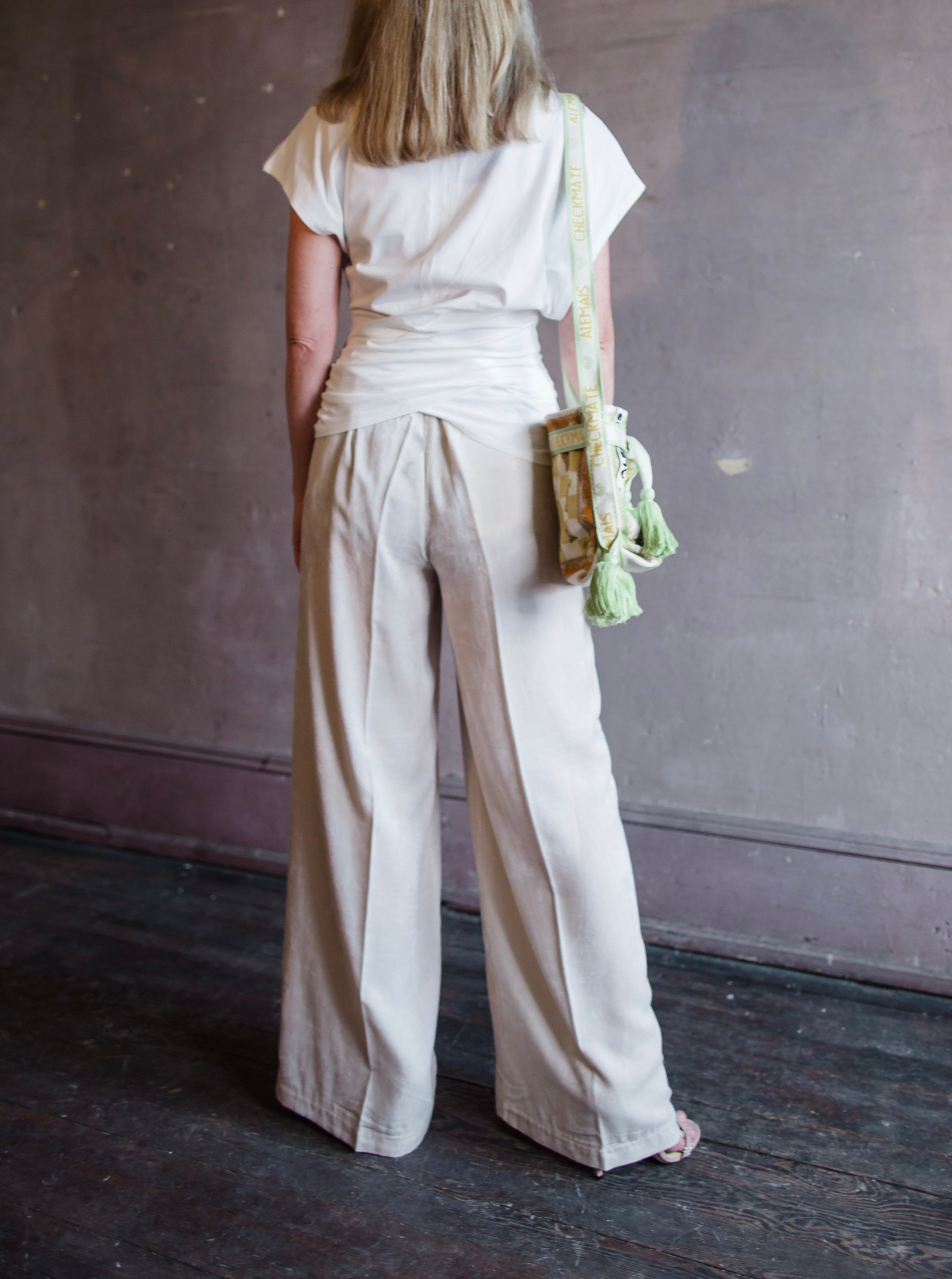 Image featuring a woman wearing the matte corduroy pants by Forte Forte with an elastic waist and flowy wide leg in ivory.