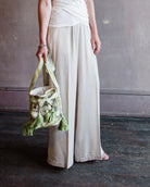 Image featuring a woman wearing the matte corduroy pants by Forte Forte with an elastic waist and flowy wide leg in ivory.