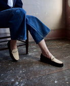 Image featuring a woman wearing the Forte Forte collaboration loafers with Sebago. They are brown leather with ivory horsehair accents and rhinestone detailing.