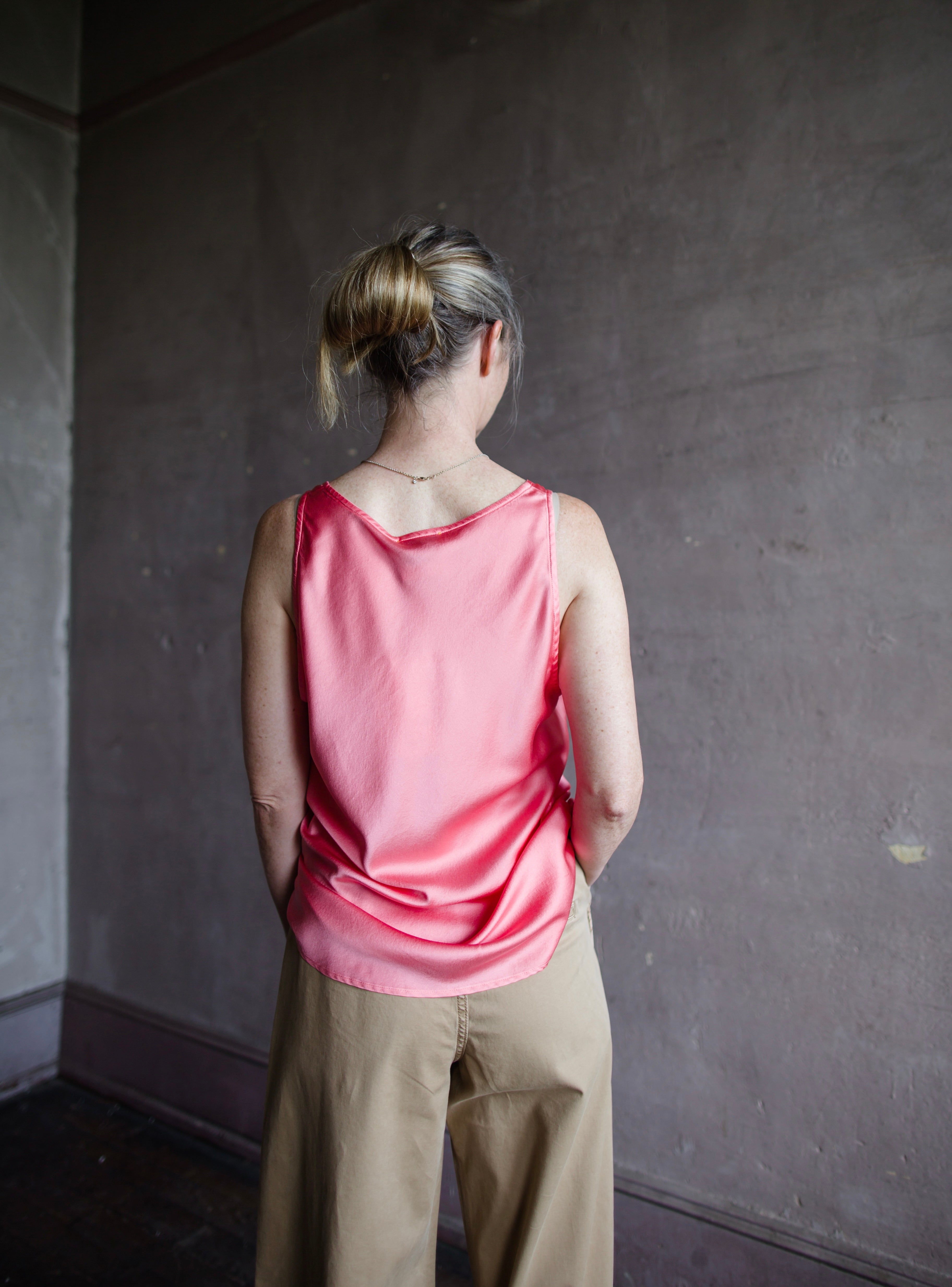 Image featuring a woman wearing the pink heavy satin silk tank by Forte Forte with a scoop neckline and relaxed fit.