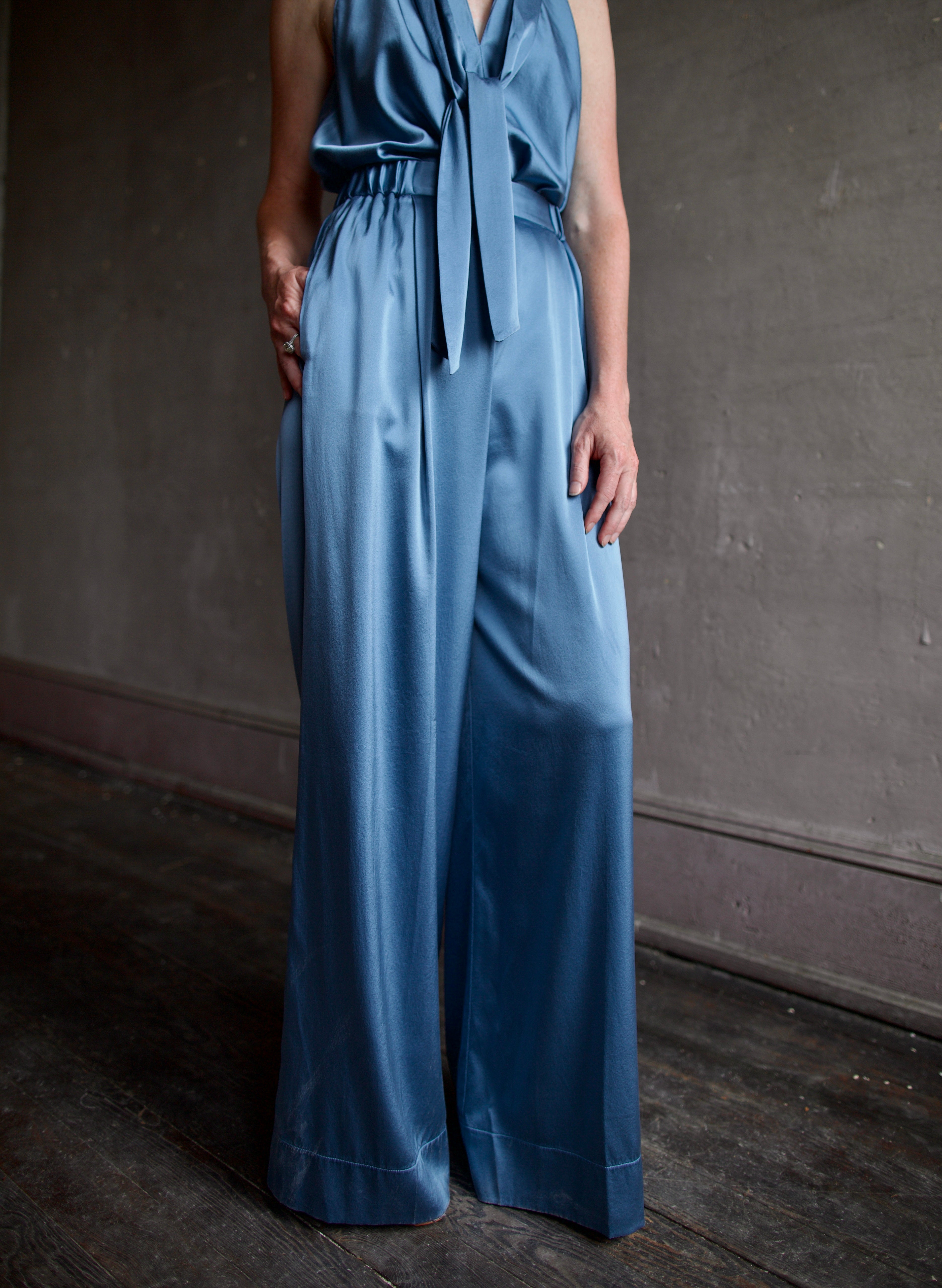 Mature model wearing luxury women's clothing Italian designer Forte Forte blue silk top and pant set 