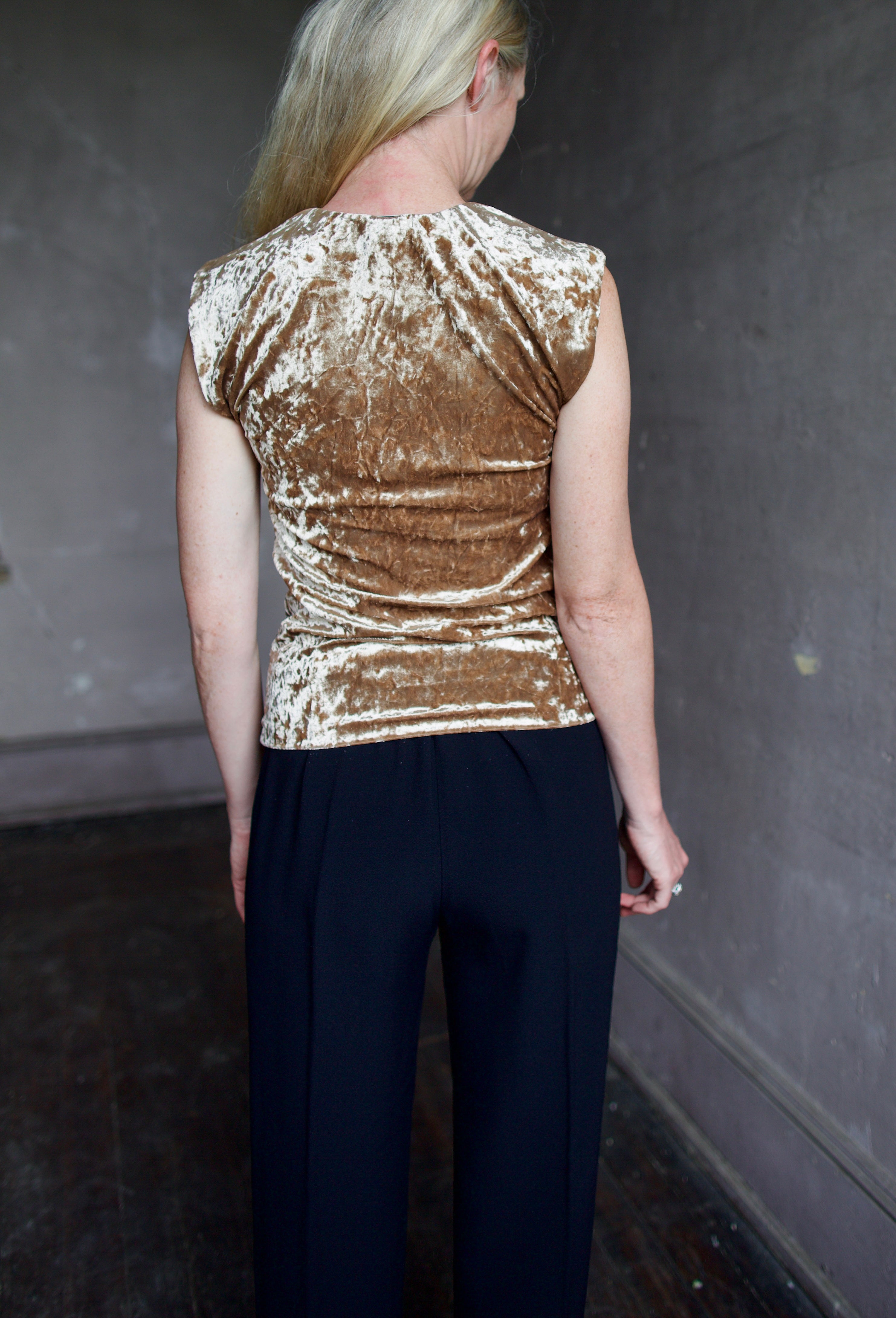 Back of mature model wearing sleeveless velvet top paired with timeless tuxedo stripe trousers from high-end Italian designer Forte_Forte