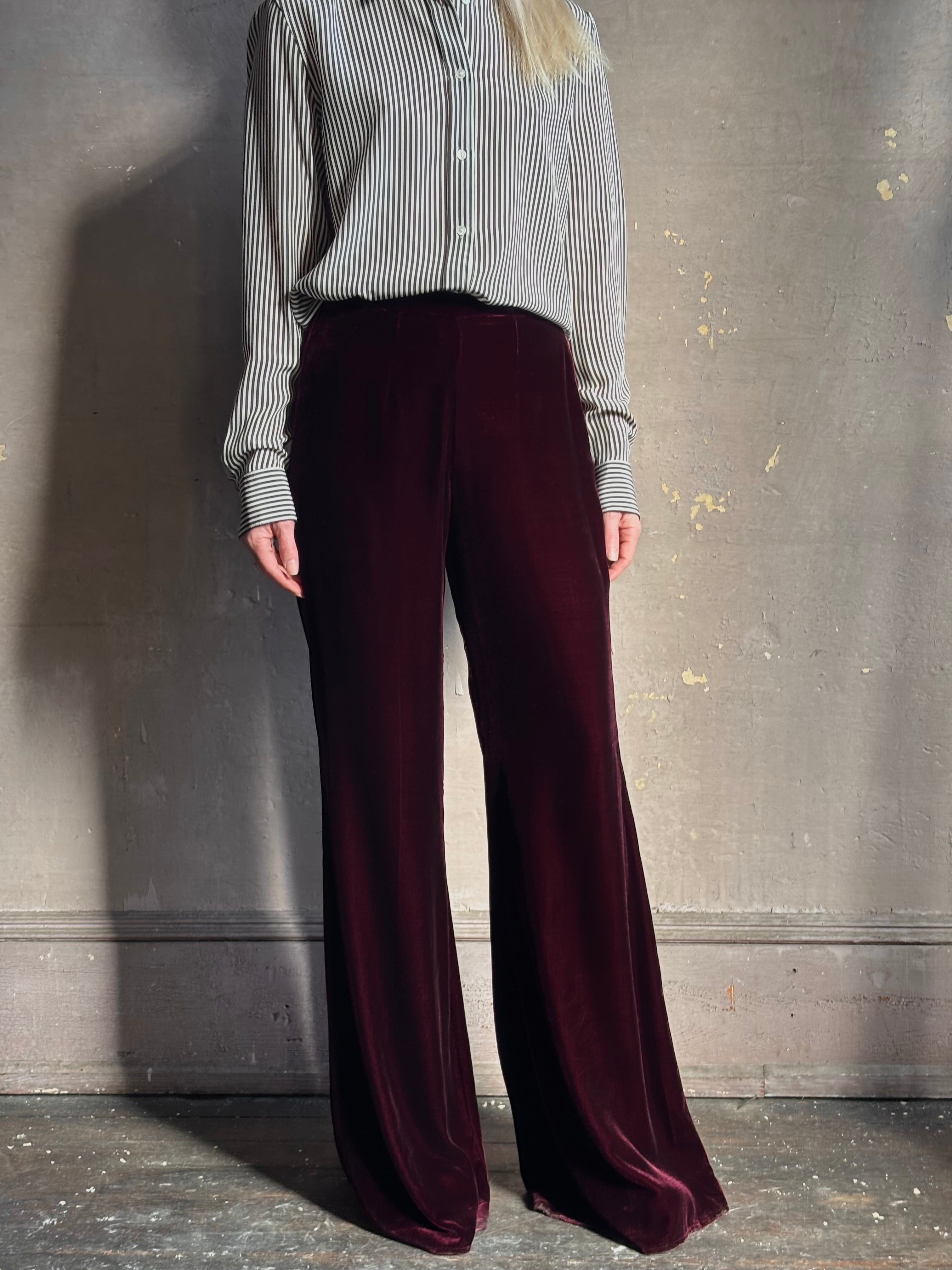 Close up of Forte_Forte Plain Velvet Flare Pants in Burgundy velvet fitted flat front fluid flare leg consealed side seam zipper
