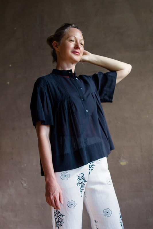 Image featuring a woman wearing the cotton top by Frame with a mandarin collar, pleated detailing down the chest that falls into soft shirring for a relaxed A-line shape in Navy blue.