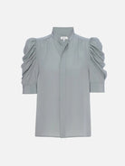 Image featuring the Frame gillian silk blouse with a high neckline and boldly puffed sleeves  in Sage Green.