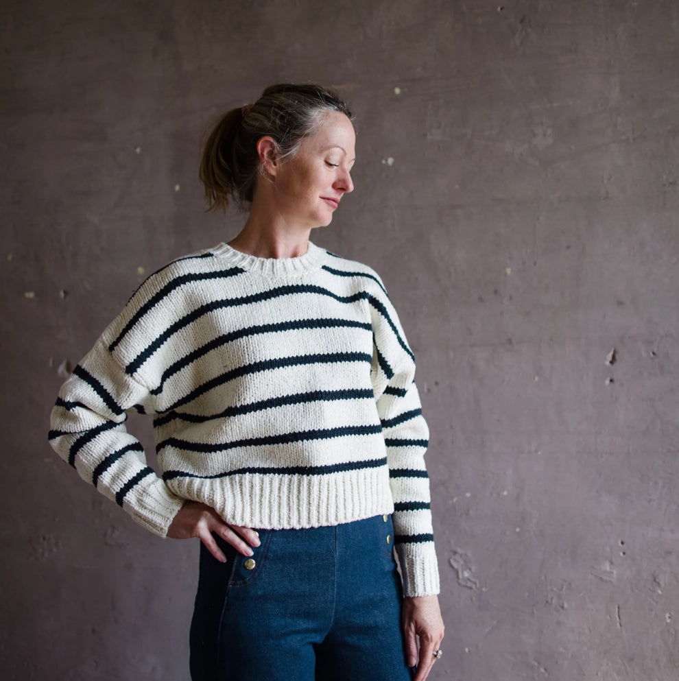 Image featuring a woman wearing the Frame blue and white stripes sweater knitted in chunky channels nautical style in a modern fit.