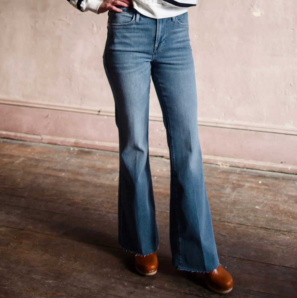 Image featuring a woman wearing the Frame Le Easy Flare Denim in the drizzle wash  with a high rise and flared leg jean.