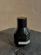 A small black bottle with a matching black cap with embossed F&R logo and a white label reading MATIA from Fulton and Roark made in USA