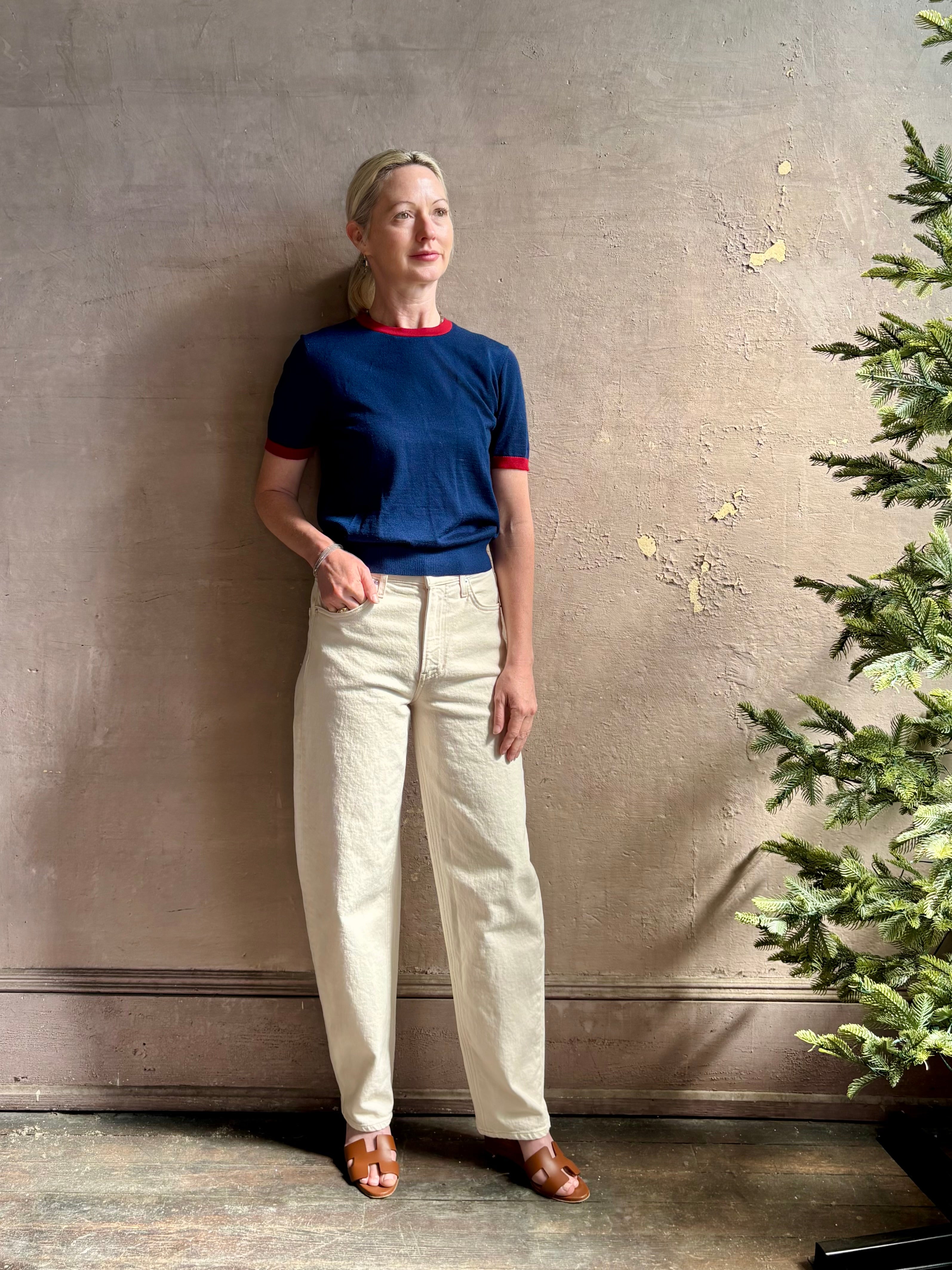 Mature woman wearing women's designer cashmere Airy short sleeve Ringer Tee from Guest in Residence rendered in a navy body with carmine ringer detailing and crafted from 100% lightweight cashmere with a crew neckline