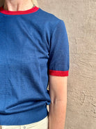 Mature woman wearing women's designer cashmere Airy short sleeve Ringer Tee from Guest in Residence rendered in a navy body with carmine ringer detailing and crafted from 100% lightweight cashmere with a crew neckline
