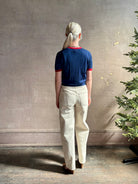 Mature woman wearing women's designer cashmere Airy short sleeve Ringer Tee from Guest in Residence rendered in a navy body with carmine ringer detailing and crafted from 100% lightweight cashmere with a crew neckline