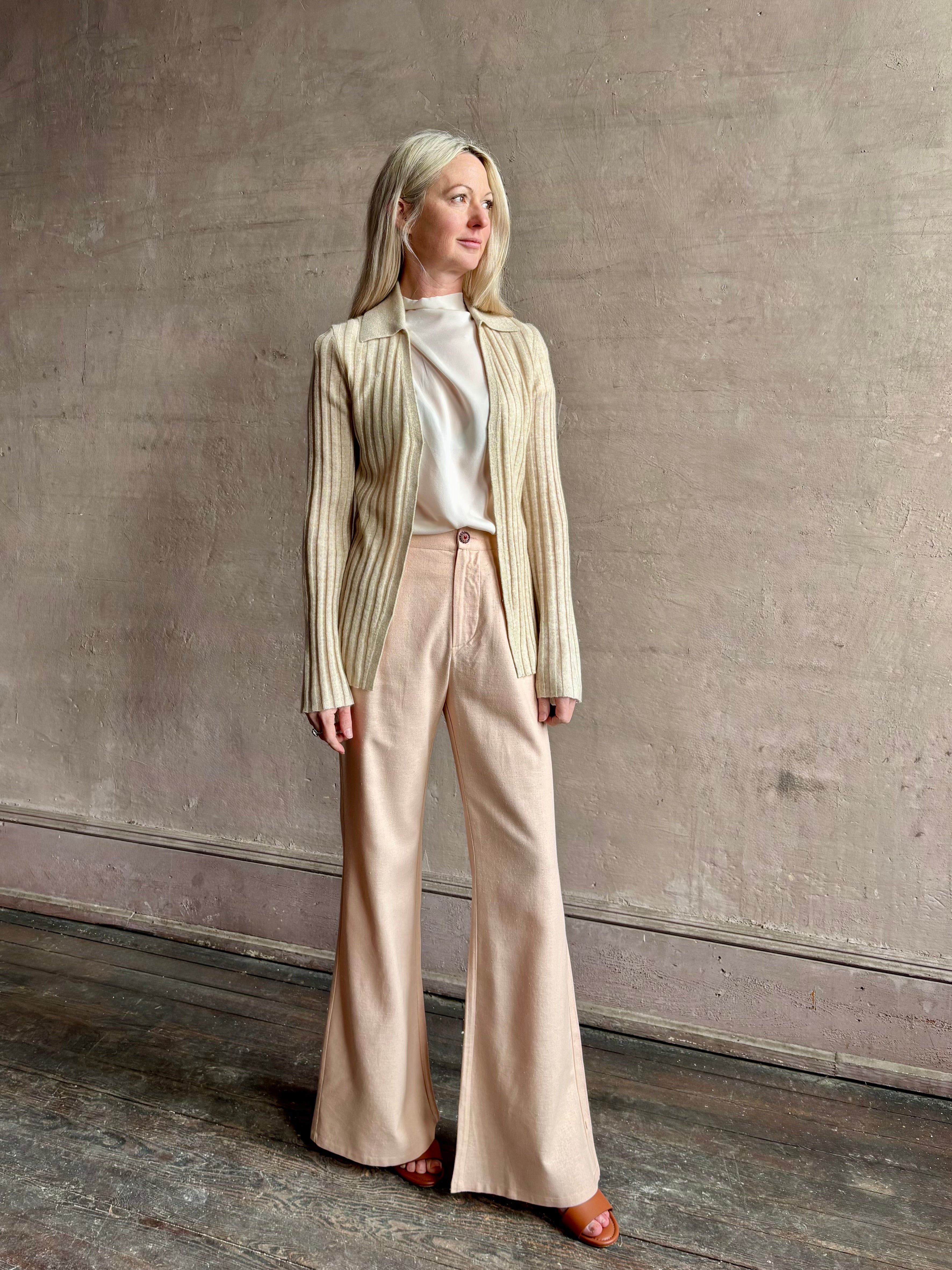 Image of mature woman wearing premium cashmere linen GUEST IN RESIDENCE Breezy Cardigan in Sandstone beige with long sleeves hook and eye front closure and ribbed texture