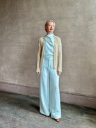 Image of mature woman wearing premium cashmere linen GUEST IN RESIDENCE Breezy Cardigan in Sandstone beige with long sleeves hook and eye front closure and ribbed texture
