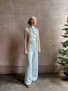 Image of mature woman wearing premium cashmere linen GUEST IN RESIDENCE Breezy Cardigan in Sandstone beige with long sleeves hook and eye front closure and ribbed texture