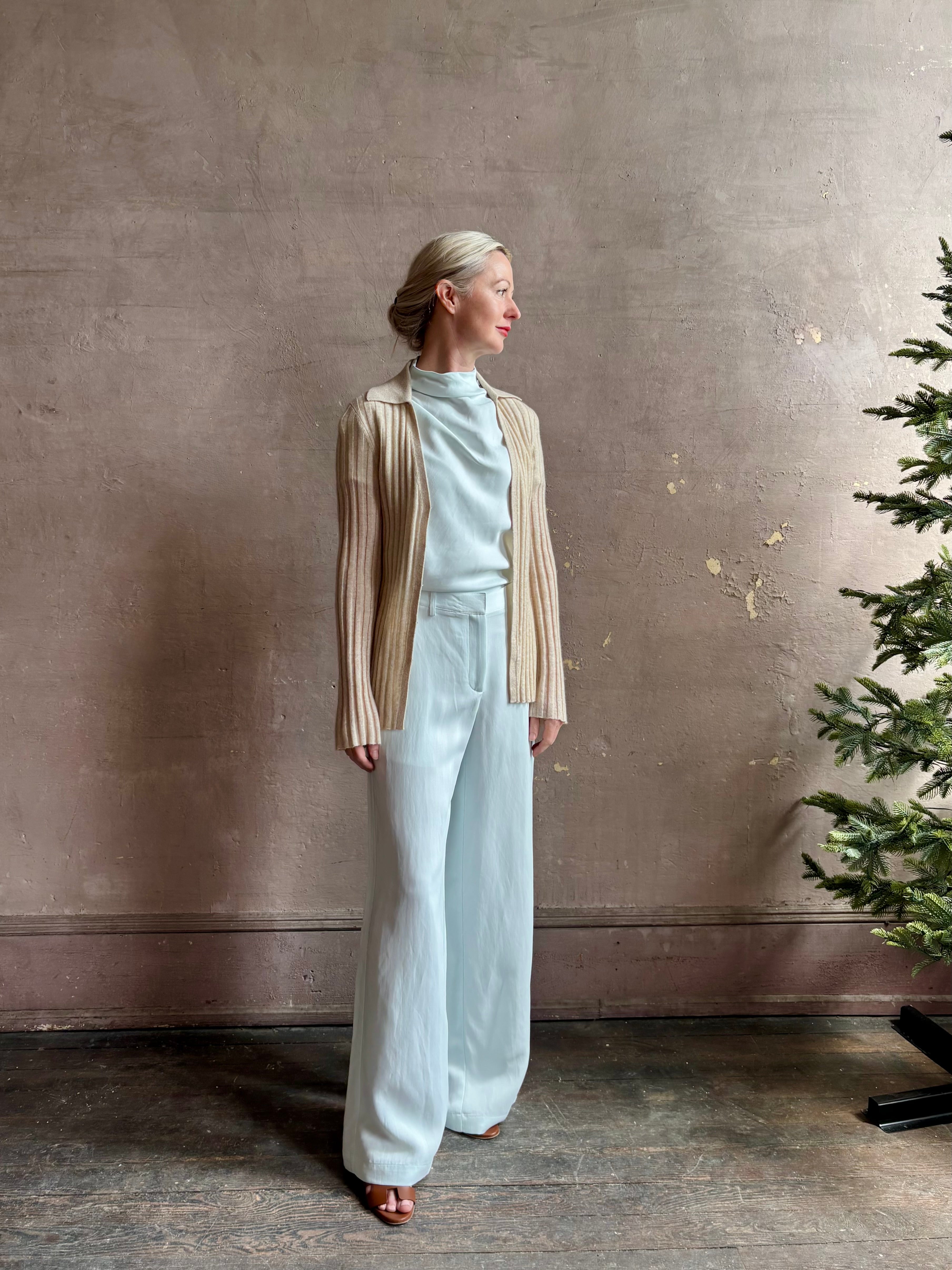 Image of mature woman wearing premium cashmere linen GUEST IN RESIDENCE Breezy Cardigan in Sandstone beige with long sleeves hook and eye front closure and ribbed texture