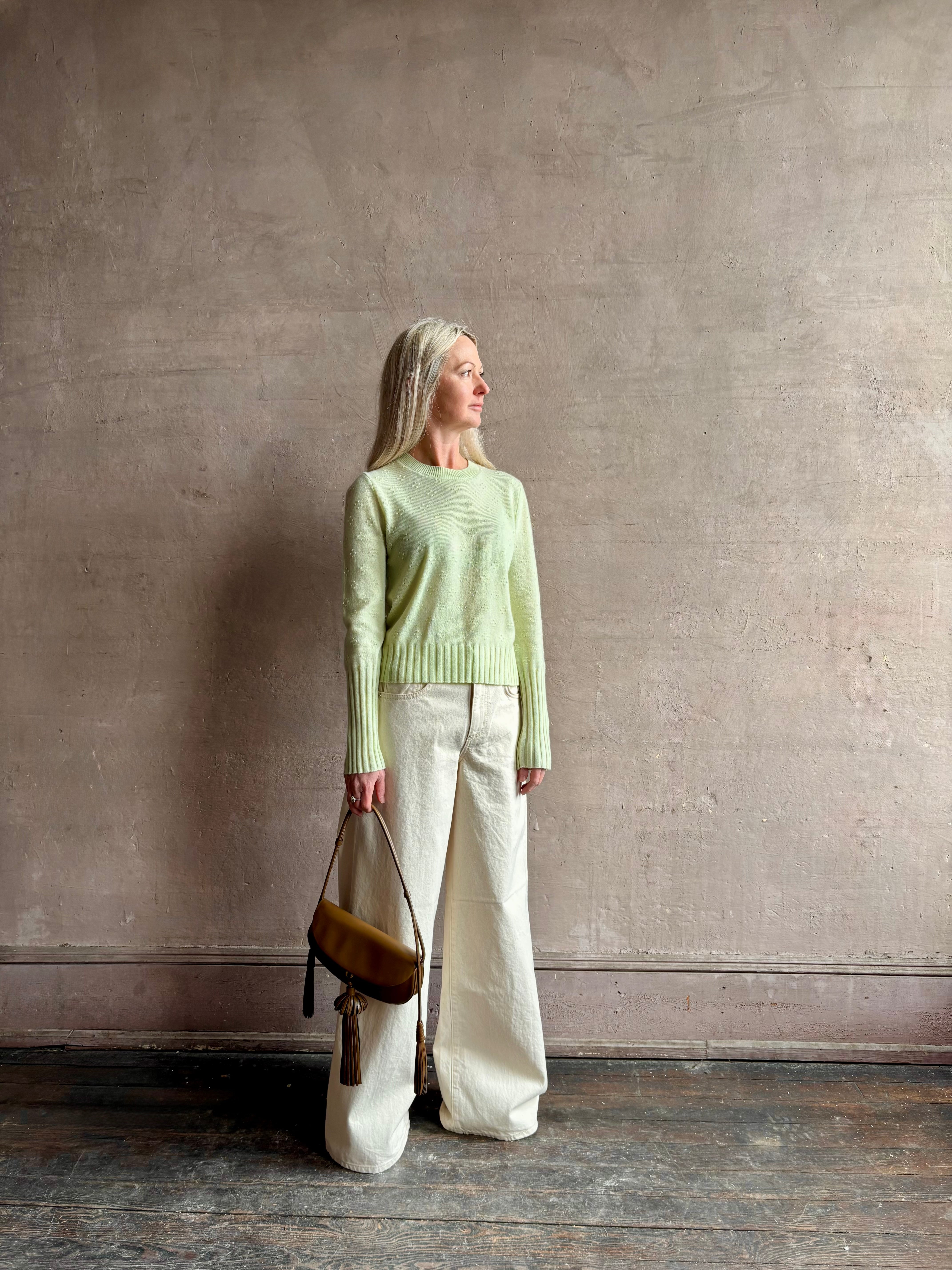 Image of woman wearing luxury cashmere crew neck sweater GUEST IN RESIDENCE Compass Shrunken Crew in Limewash Knitwear with long sleeves and dot detail throughout