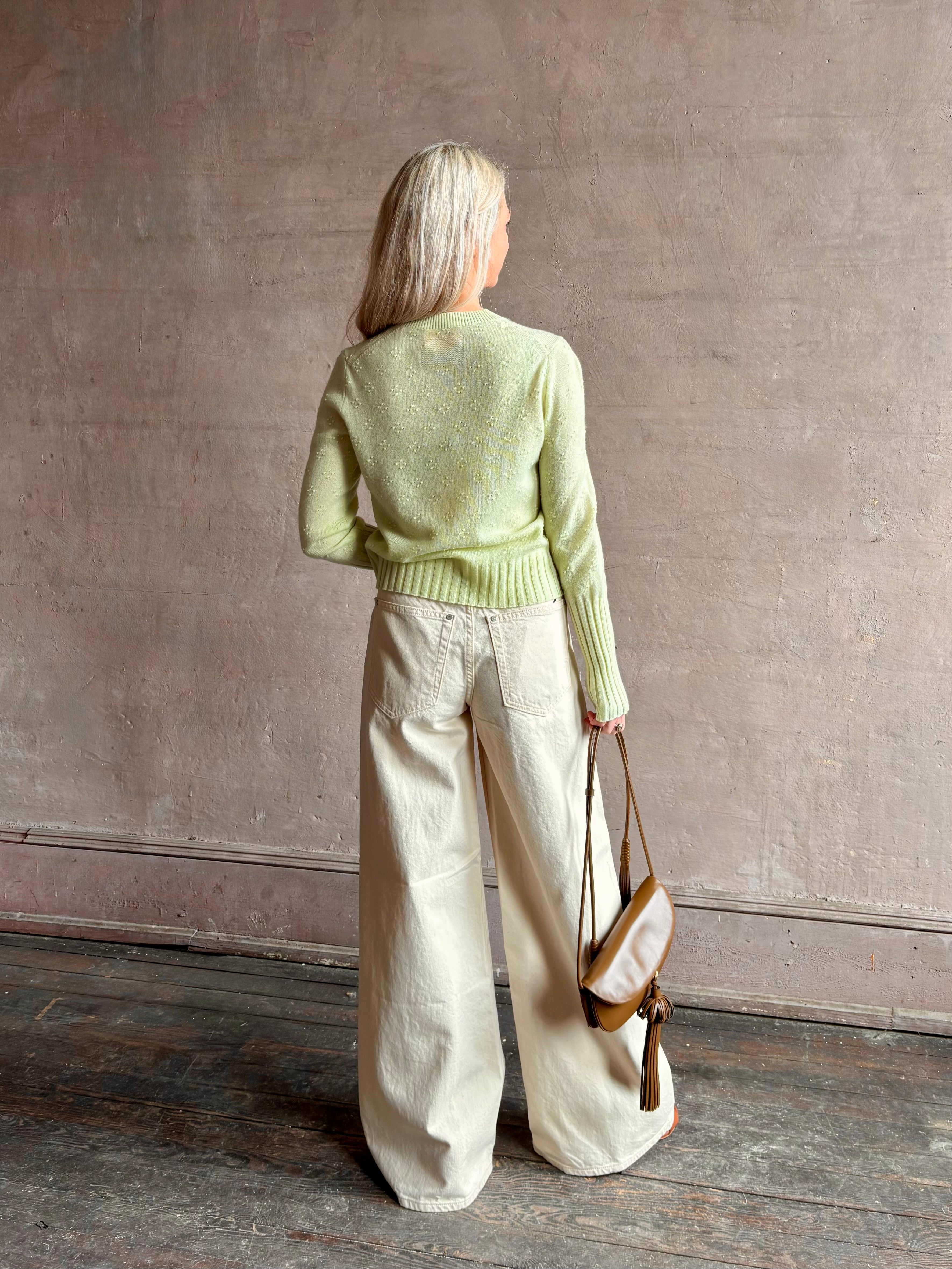 Image of woman wearing luxury cashmere crew neck sweater GUEST IN RESIDENCE Compass Shrunken Crew in Limewash Knitwear with long sleeves and dot detail throughout