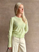 Image of woman wearing luxury cashmere crew neck sweater GUEST IN RESIDENCE Compass Shrunken Crew in Limewash Knitwear with long sleeves and dot detail throughout