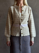 mature woman wearing Guest in Residence Fairisle Cardigan in cream and beige pattern with a subtle lavender  knit accent at waistline