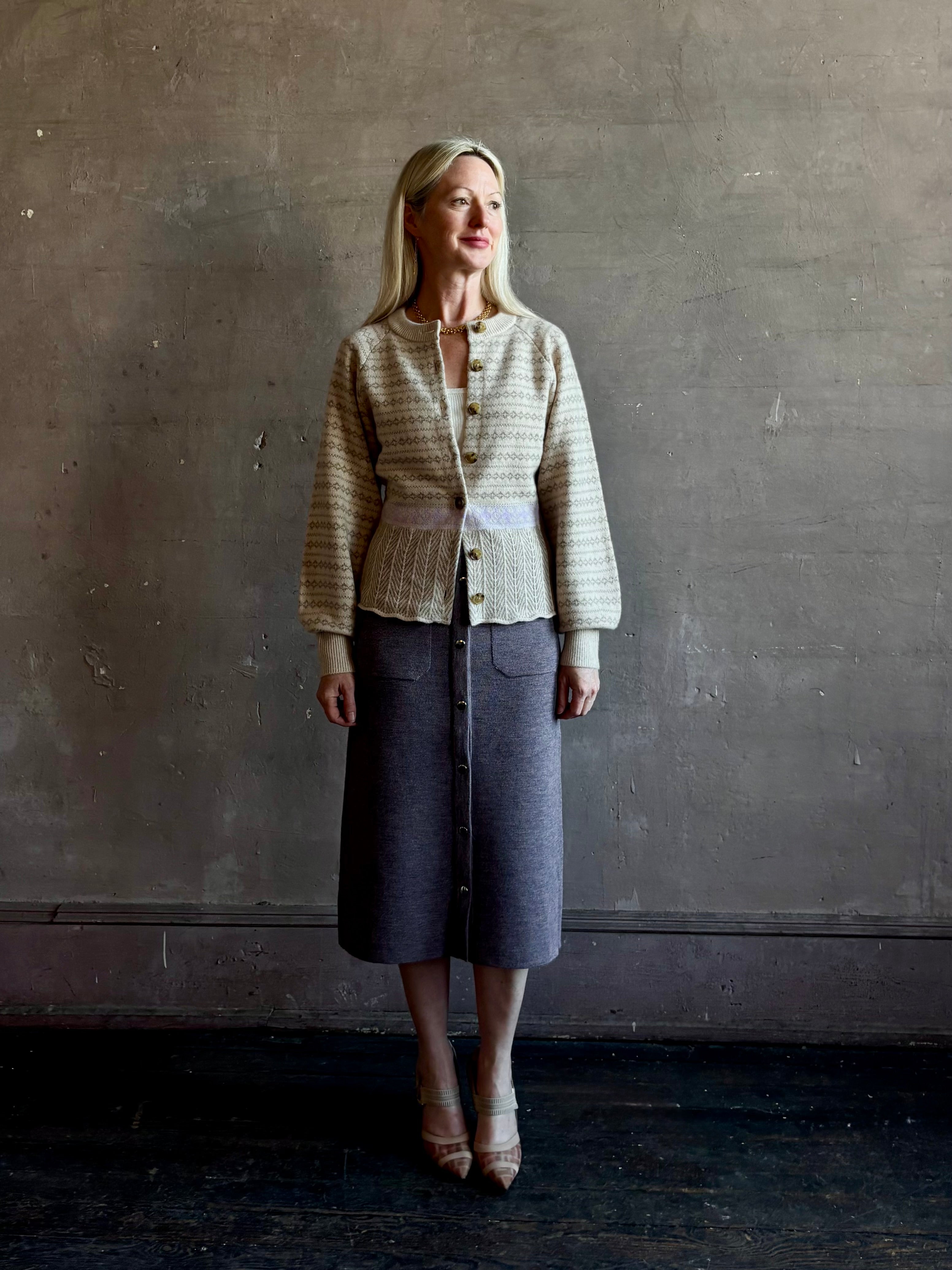 mature woman wearing Guest in Residence Fairisle Cardigan in cream and beige pattern with a subtle lavender  knit accent at waistline