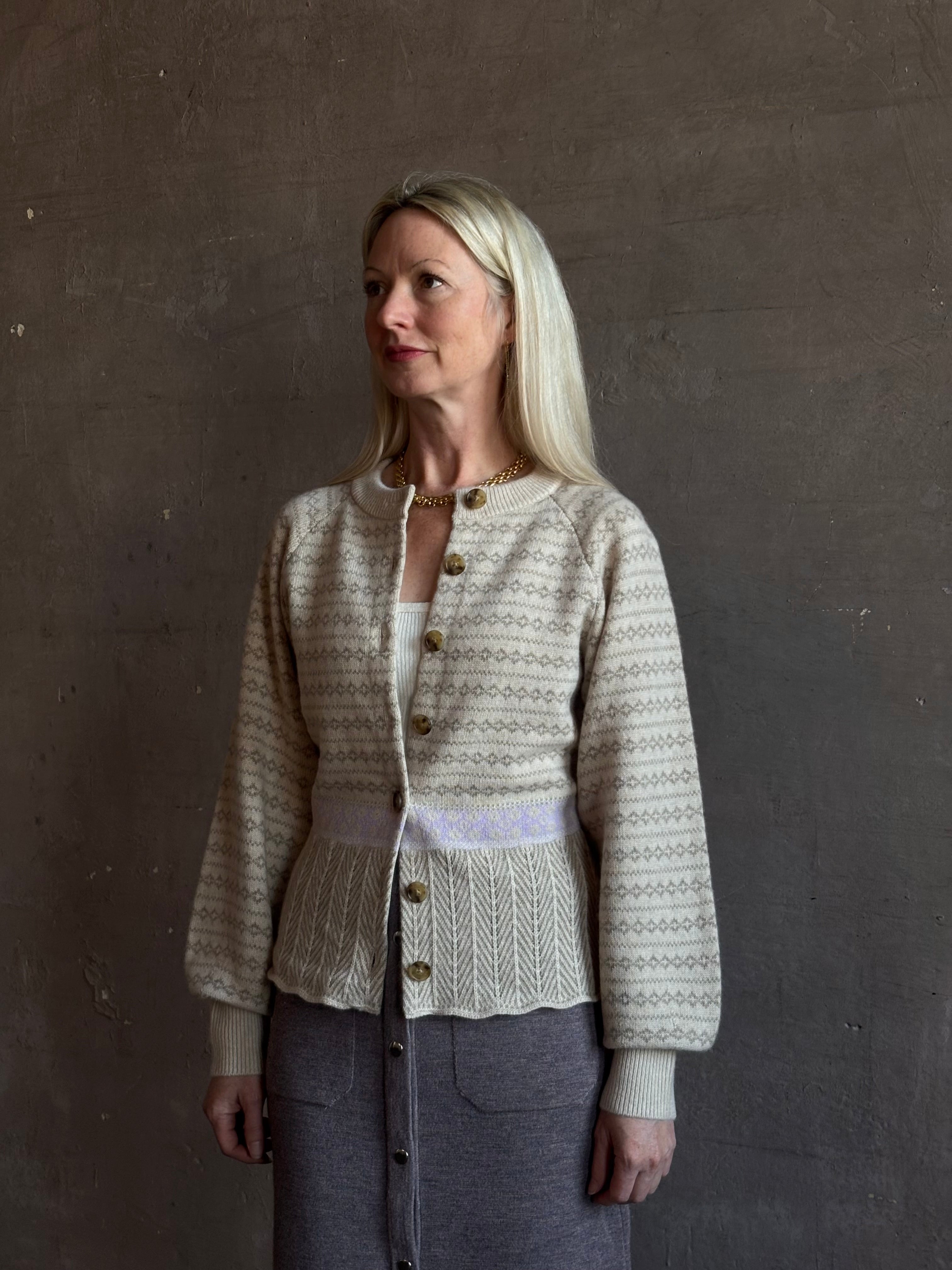mature woman wearing Guest in Residence Fairisle Cardigan in cream and beige pattern with a subtle lavender  knit accent at waistline