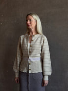 mature woman wearing Guest in Residence Fairisle Cardigan in cream and beige pattern with a subtle lavender  knit accent at waistline