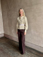 Image of mature woman wearing Guest in Residence Fairisle Cardigan in cream and beige pattern with a subtle lavender  knit accent at waistline