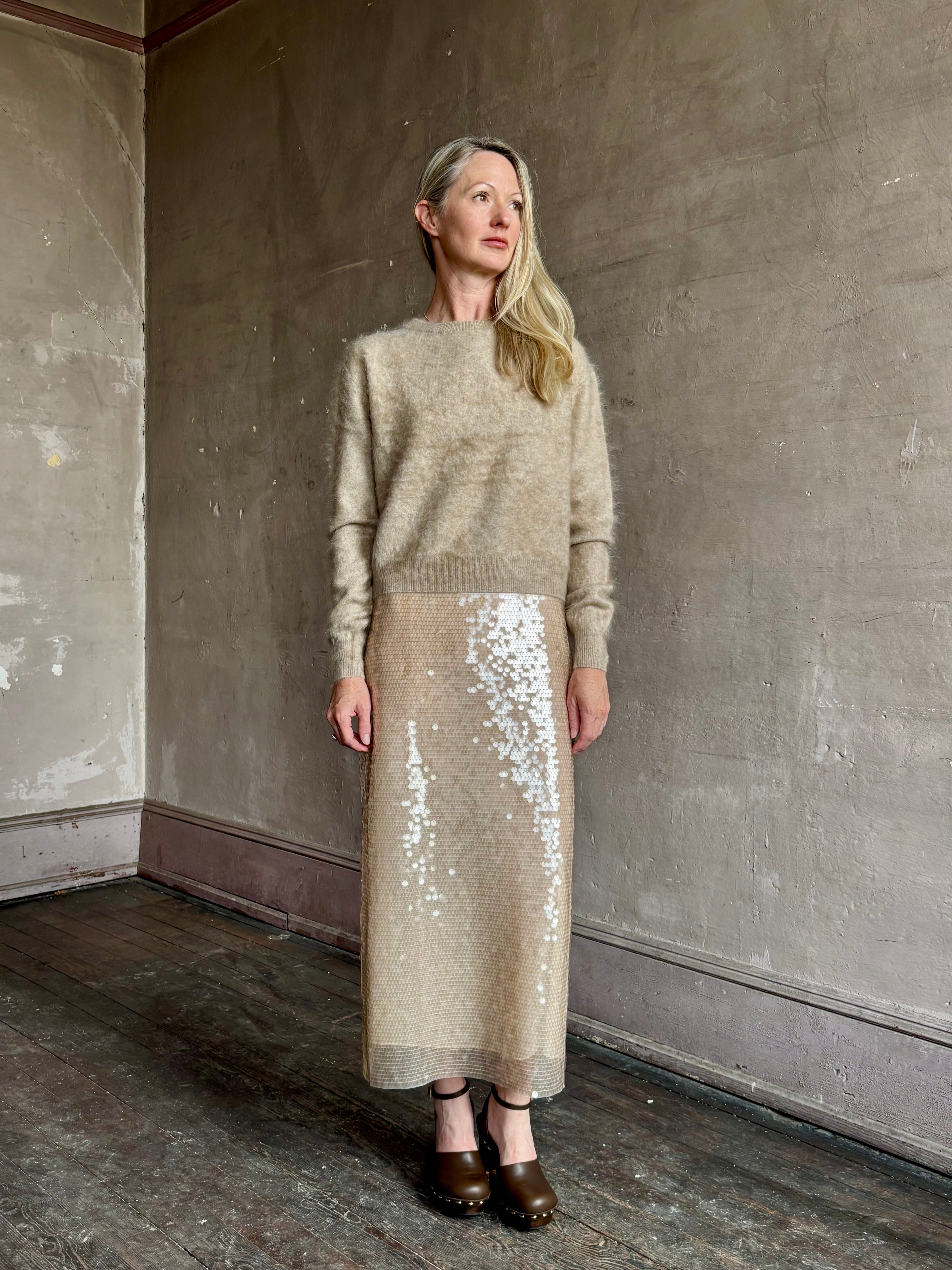 Image of mature model wearing New York luxury women's clothing brand Guest In Residence long-sleeve crew neck brushed cashmere beige sweater