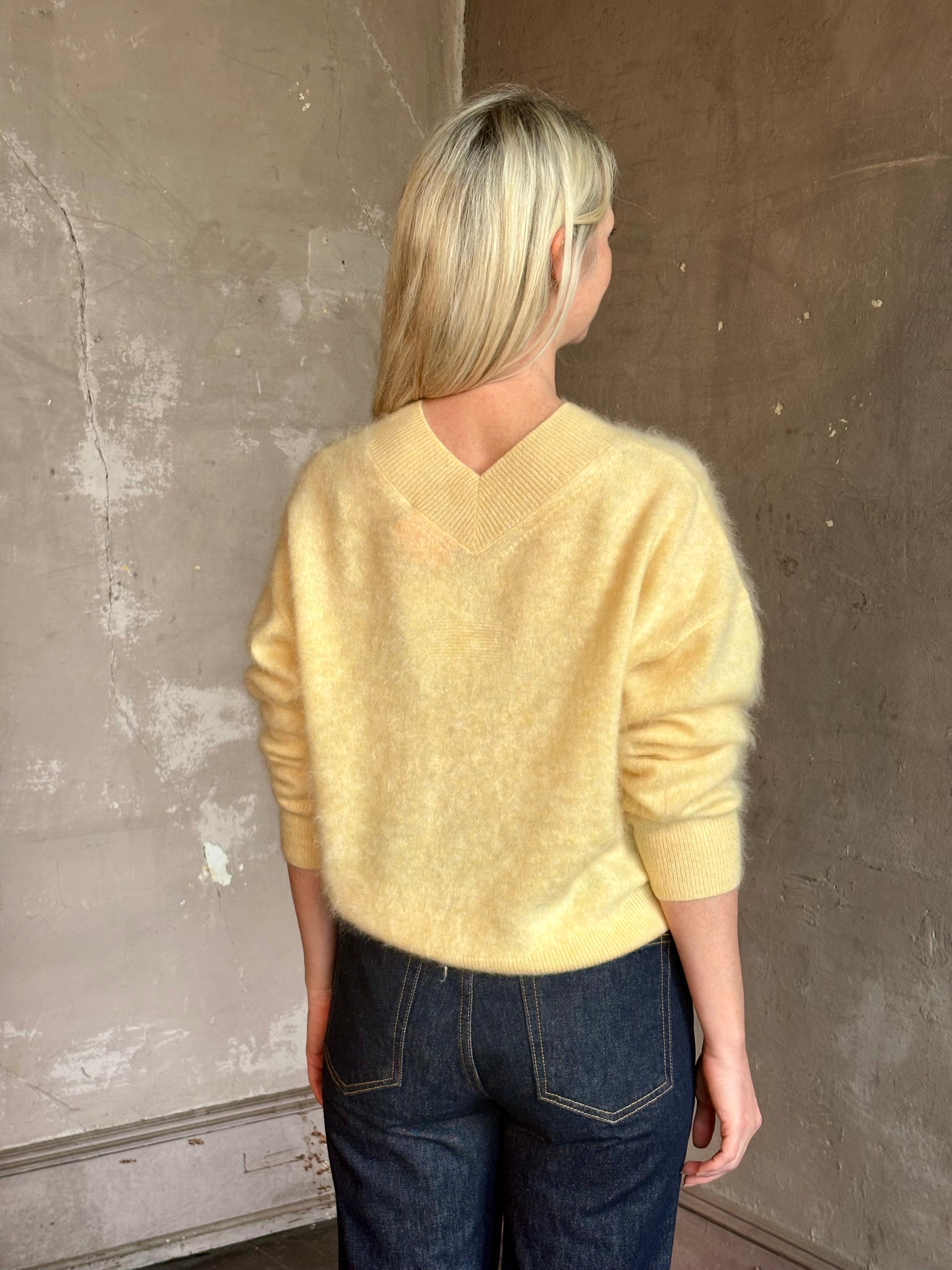 Mature woman wearing Guest in Residence Grizzly Double V Sweater in Butter brushed cashmere front-and-back V-necklines long sleeves