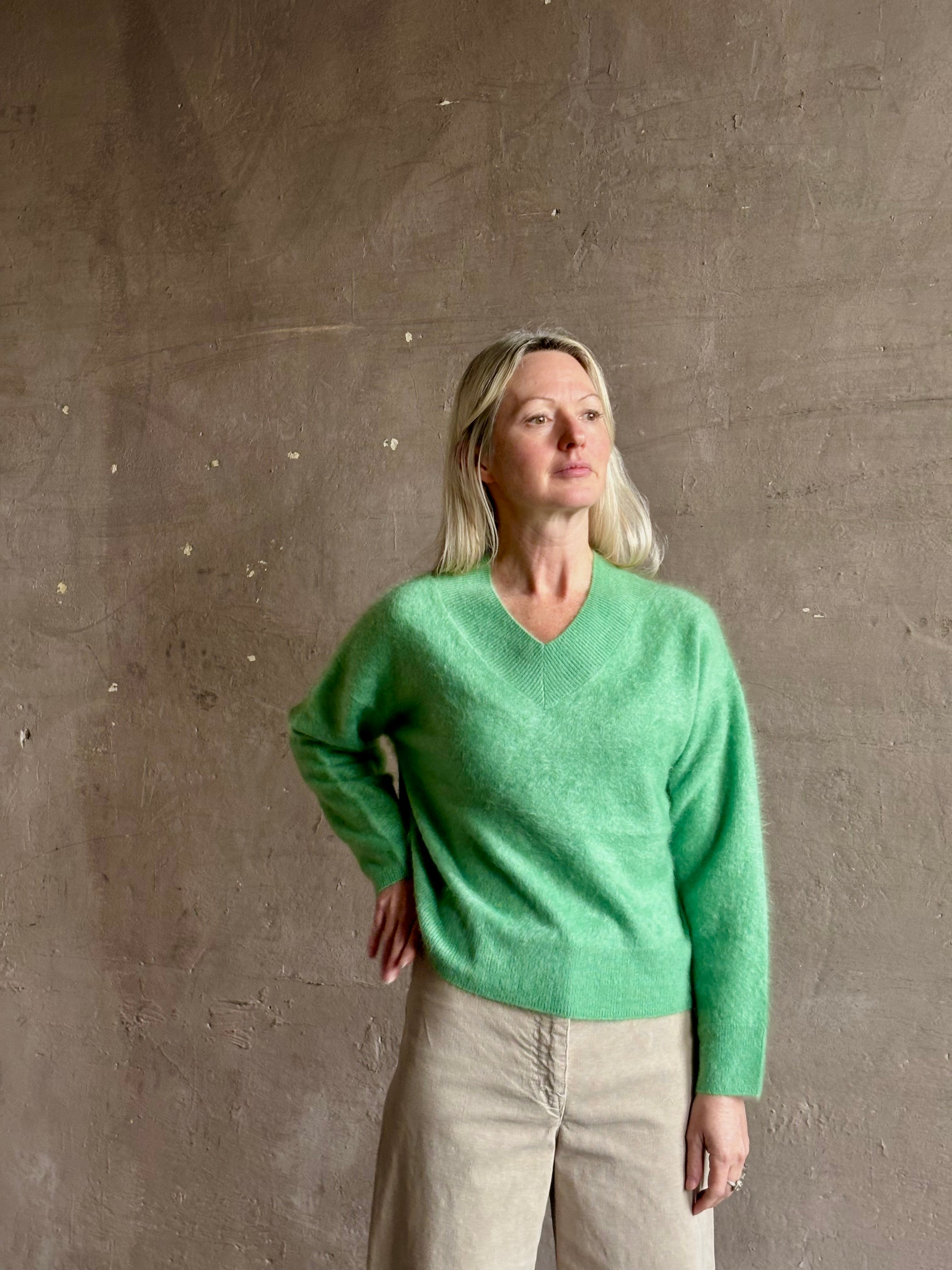 Mature woman wearing Guest in Residence Grizzly Double V Sweater Highland Green brushed cashmere with symmetrical front-and-back V-necklines