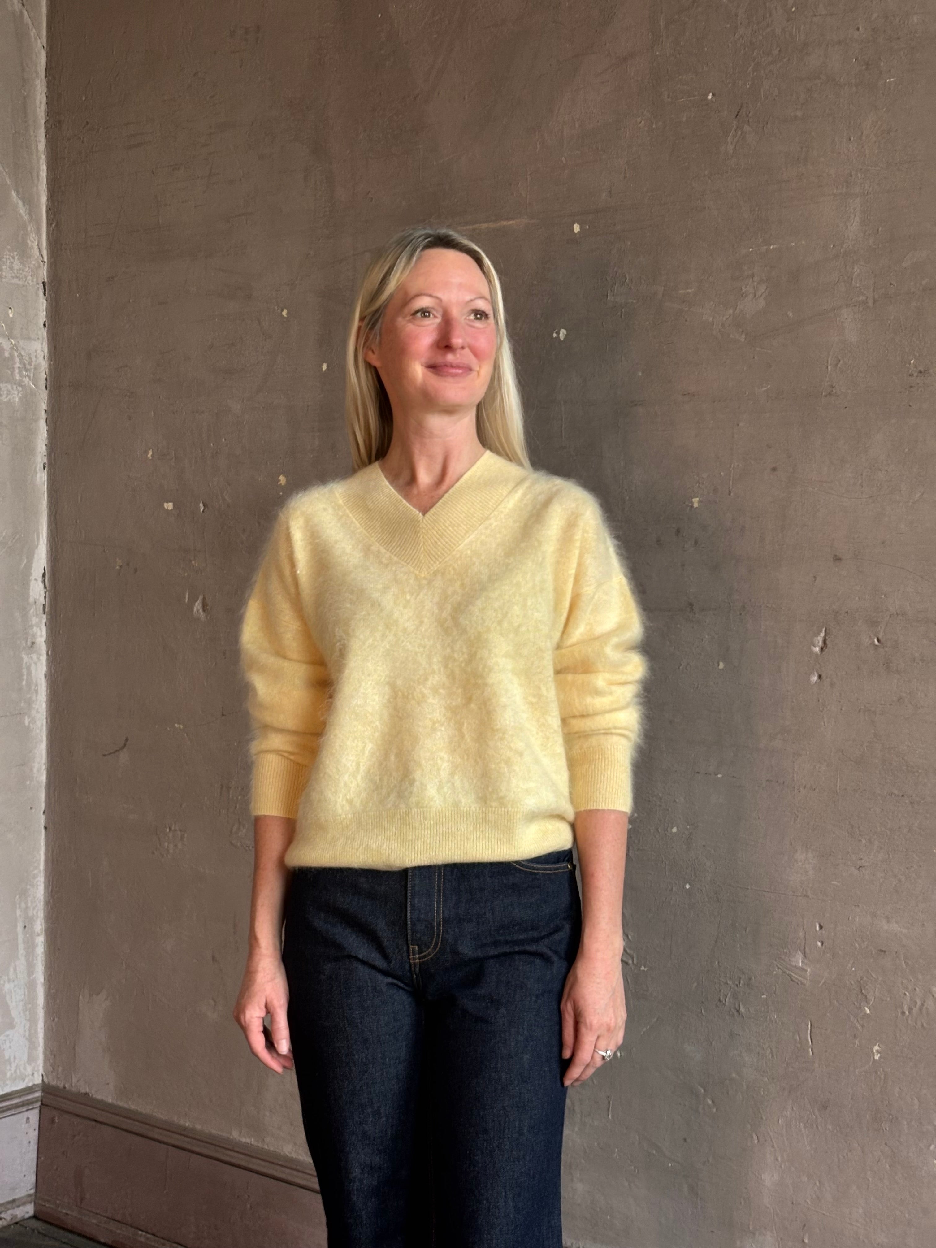 Mature woman wearing Guest in Residence Grizzly Double V Sweater in Butter brushed cashmere front-and-back V-necklines long sleeves